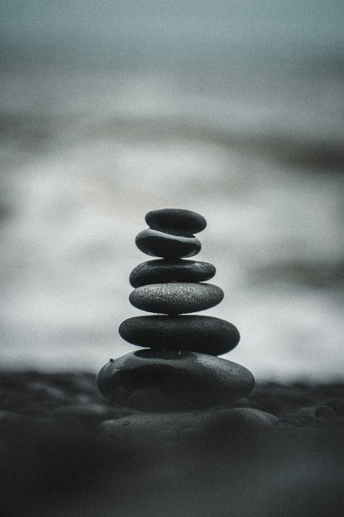 Stack of stones balanced on a beach with a blurred background